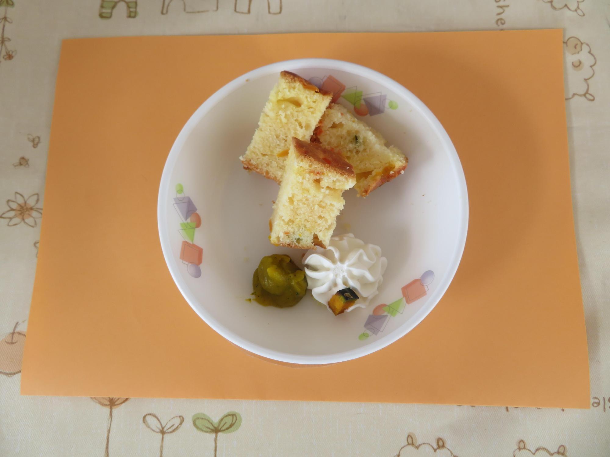 オレンジ色のランチョンマットに乗ったパンプキンケーキを真上から撮影した写真