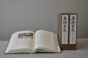 高砂市史第一巻「通史編 地理・考古・古代・中世」のサンプル写真。直立した函の左に、ハードカバーの本が見開きで配置されている
