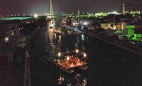 夜の堀川を明かりのついた御座船が進んでいく様子の写真