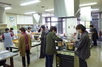 地区公民館でおこなわれたあやめ教室でそれぞれ役割分担をしながら料理を作る地区婦人会の女性たちの写真