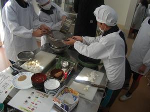 児童たちが実際に調理を行っている写真で、野菜を細かく刻んだり笊で食材を漉したりしている。