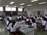 校舎内の特別教室で地球温暖化についての講義を受ける生徒たちの写真