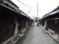 焼き板を壁材にした昔づくりの長屋が道沿いに並んでいる写真