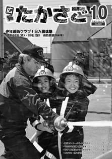 広報誌の10月号にて消防服を着た子供二人が消防員と一緒に消火ホースで放水している白黒写真が載っている表紙