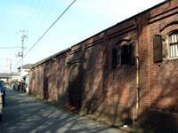 レンガ造りの倉庫が道に沿って奥に続いている写真