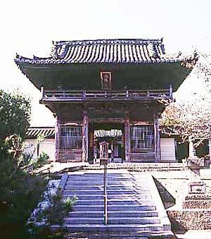 石造りの階段の上にそびえたつ時光寺山門の写真