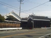 道路沿いに複数の白い蔵造りの建造物が並んでいる写真