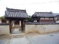 白い石壁の塀に囲まれた神宮寺山門の写真
