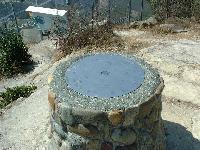 円柱の天井部に円盤が植え込まれている石造りの方位盤の写真