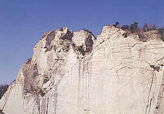 断崖絶壁のように切り取られた採石場の大きな岩の写真