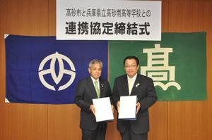 高砂市長と兵庫県立高砂南高等学校の職員の男性が協定書を持っている写真