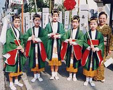 荒井神社のお祭りで頭に輪っかをつけ、半被のようなお揃いの衣装を着た5人の女性の写真