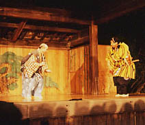舞台の両脇に立っている、和服の装束を着た2名の演者の写真