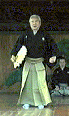 紋付袴姿の男性が扇子を手にして仁王立ちしている写真