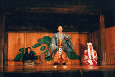 能の舞台の上で、和服の装束を着て舞を踊る男性の写真