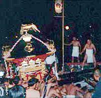 夜間に神輿を担ぐ祭りの風景の写真