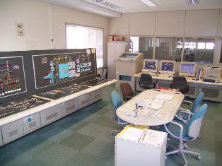 パソコンや制御設備、会議テーブルがある監視室の写真