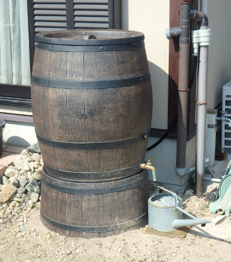 家の外に設置された樽型の雨水貯留タンクの写真