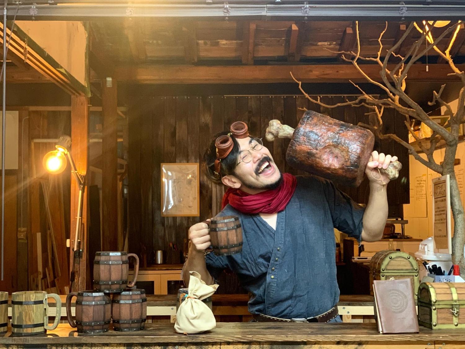 ファンタジーゲームの世界観をイメージした酒場のカウンターの前で大きな骨付き肉と木製のジョッキを手に持つ笑顔の男性