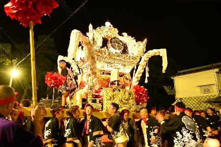 夜に神輿をかつぐ写真