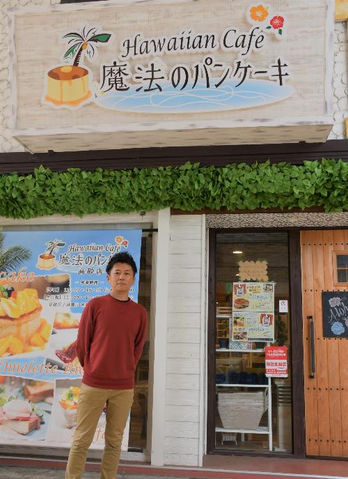 パンケーキ屋さんの前で立つ男性の写真