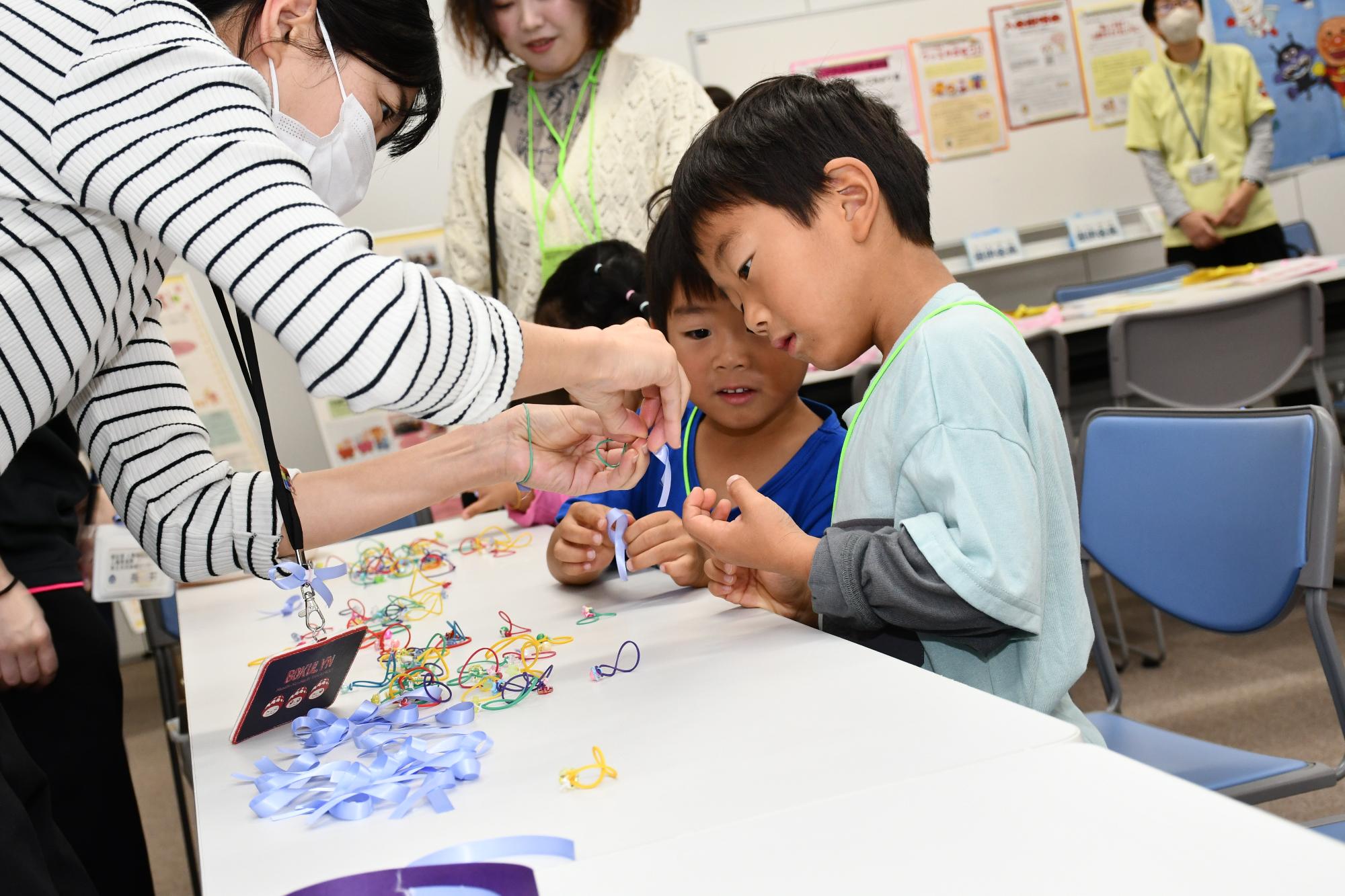 女性に対する暴力をなくす運動のシンボルであるパープルリボンを作成する子どもたち