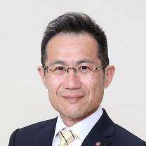 黒いスーツ姿で正面を向いている笑顔の山田光昭議員の写真