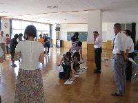 広い板張りの部屋で不審者対応訓練の講習を受ける伊保小学校の教職員たちの写真