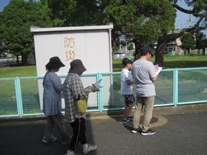 防災と書かれた屋外設備の前を通る4人の参加者の写真