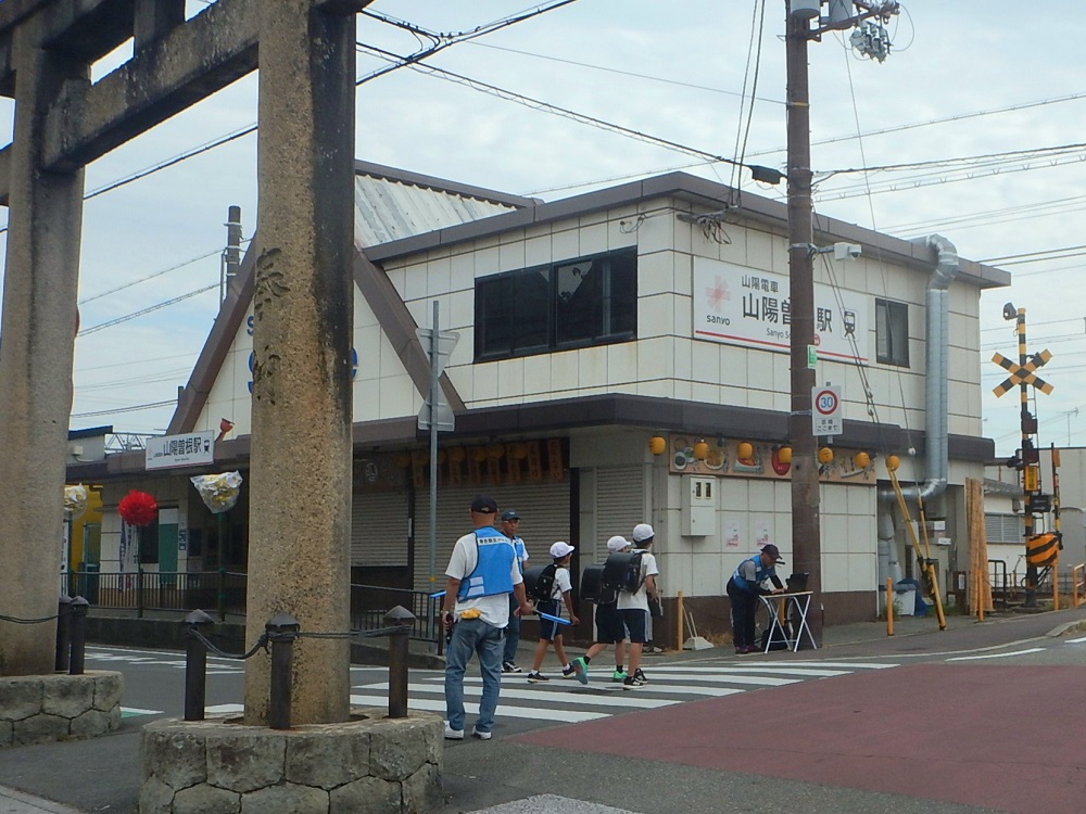 小学生の下校見守りで横断歩道に立っている青色防犯パトロール員のようす