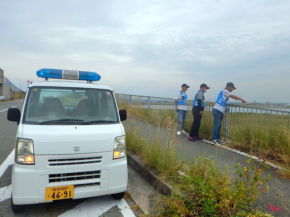 川べりで危険箇所の点検を行っているパトロール員の写真