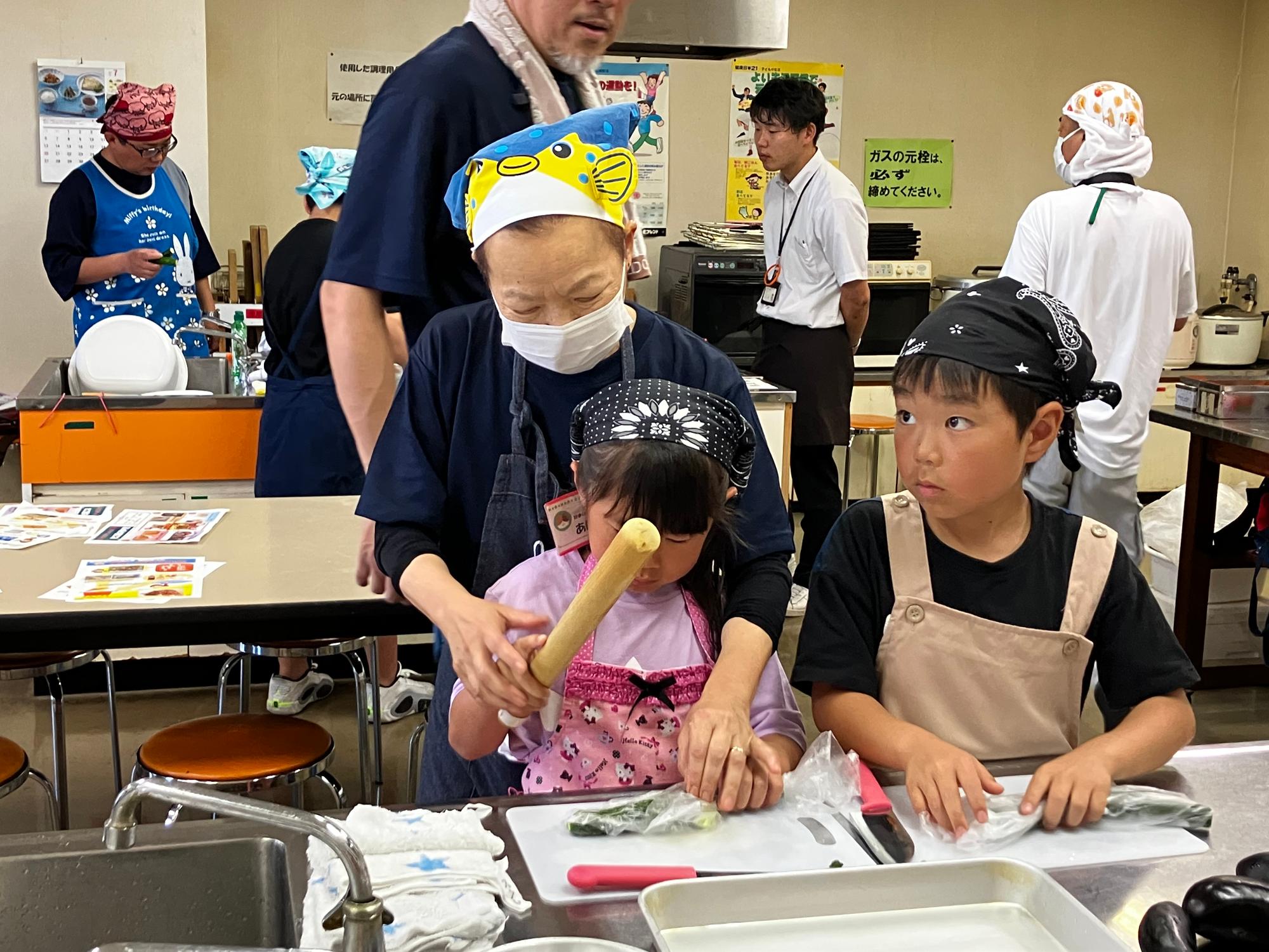 手をとって、お料理の仕方を教えてもらっている様子